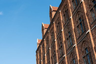 Leuven, Flaman Brabant Bölgesi, Belçika - 09 22 2021: Mavi gökyüzü geçmişe sahip bir Katolik geleneksel okulun tuğla taş cephesi