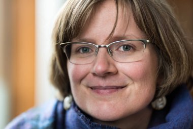 Beyaz, yaşlı bir kadının kapalı alanda çekilmiş portresi.