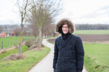 Aktif 40 yaşında, büyük kışlık ceketli, şapkalı bir adam.