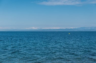 Slovenya 'nın Piran kentinde arka planda dağların olduğu minimalist tarzda mavi deniz manzarası