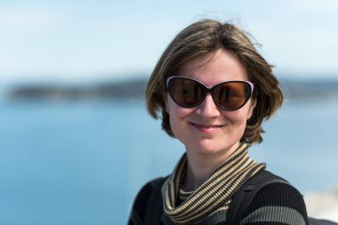 30 yaşında gülümseyen beyaz bir kadının deniz kenarındaki resmi, Piran, Slovenya