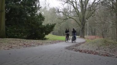 Oud-Heverlee, Flaman Brabant, Belçika - 12 18 2021: Dyle nehri parkından geçen bisikletli öğrenciler