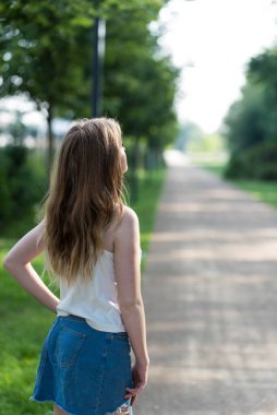 Çekici bir kadın portresi. 21 yaşında, beyaz bir kadın, sırtını açık araziye çeviriyor.