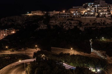 Akdeniz, evler ve kaya yapılarıyla Malta 'daki Mellieha körfezi üzerinde gece görüşü