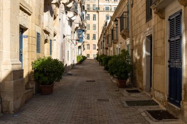 Valletta, Malta - 01 06 2022: Eski kasabada sarı cepheli dar sokaklar