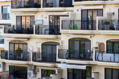 Mellieha, Malta - 01 07 2022: Bir tatil apartmanının balkonları ve pencereleri