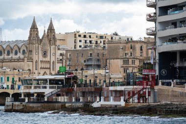 Saint Julian, Malta - 01 07 2022: Tekneler, Akdeniz ve tatil evleriyle körfezin kıyı şeridine bakın