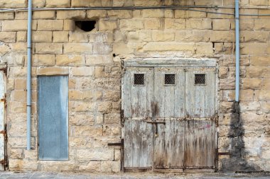 Saint Julian, Malta - 01 07 2022: Deniz kenarında eskimiş kahverengi cephe ve ahşap kapılar