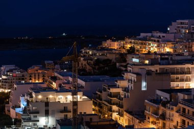 Mellieha, Malta - 01 07 2022: Gece yüksek açı manzarası vadiden deniz kenarına doğru