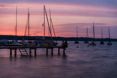 Seeshaupt, Bavyera - Almanya - 08 03 2018: Yaz aylarında gün batımında dinlendirici gölün limanında küçük tekneler