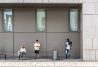 Ingolstadt, Bavyera - Almanya - 07 27 2018: Otobüsü bekleyen siyah erkek, Asyalı erkek ve beyaz kadın