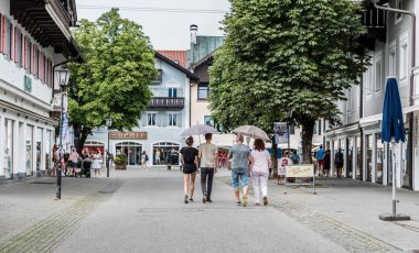Garmisch Partenkirchen, Bavyera / Almanya - 08 05 05 2018: Yaz tatillerinde eski kentin sokaklarında aile yürüyüşü