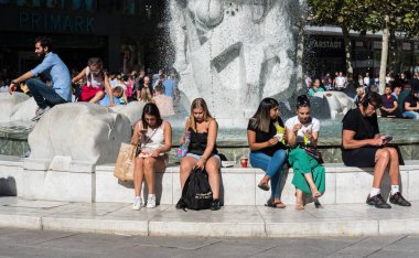 Frankfurt am Main, Hesse / Almanya - 08 11 11 2018: Hauptwache civarındaki ticaret alanındaki çeşmede oturan gençler