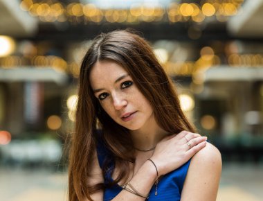 18 yaşında kızıl saçlı güzel bir kızın moda portresi kısa mavi elbiseyle bacak bacak bacak üstüne atmış.