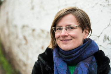 Yaşlı beguinage 'da beyaz bir duvara poz veren genç bir kadın.