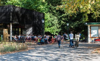 Schaerbeek, Brüksel / Belçika - 10: 15 2018: Yerel halk sıcak bir sonbahar gününde parkta terasta oturuyor