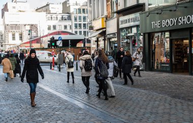 Brüksel, Belçika - 12: 18 2018: Mutlu bekar kız kışın eski bir kasabada alışveriş caddesinde yürüyor