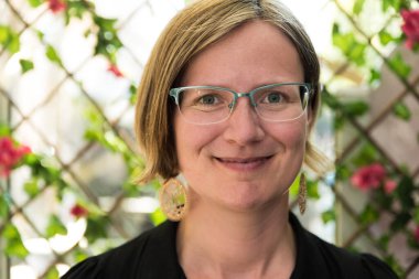 Otuz yaşında, beyaz, cam küpeli, siyah elbiseli, beyaz bir kadının portresi.