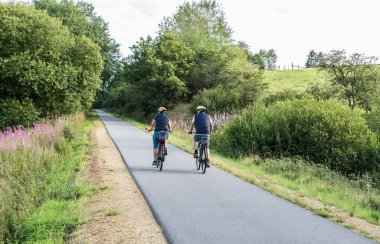 Bullingen, Walloon Bölgesi - Doğu Belçika - 08 27: 19 RAVeL 'de bisiklet süren yaşlı bir çift, bir doğa parkında bisiklet yolu