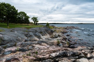 Baltık Denizi kıyılarında kara bulutlar ve vahşi kayalar Oregrund, Uppland - İsveç