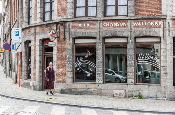 Tournai Doornik, Walloon Bölgesi - Belçika - 08 14 2019 Eski şehrin yerleşim alanlarında yürüyen bir rahibe