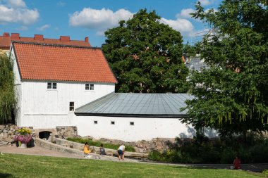 Uppsala, Uppland- İsveç - 07 27 2019 İnsanlar ve aileler küçük bir şehir parkında eğleniyor