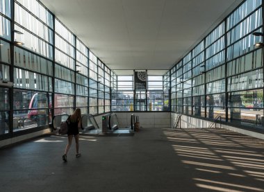 Uppsala, Uppland - İsveç - 07 27 2019: Sarışın genç kız tren istasyonunun çıkış merdivenlerine doğru yürüyor