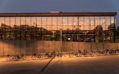 Uppsala, Uppland - İsveç - 07 27 2019 - Demiryolu istasyonunun tünelinin yakınına park edilmiş bisikletler altın güneşi yansıtan