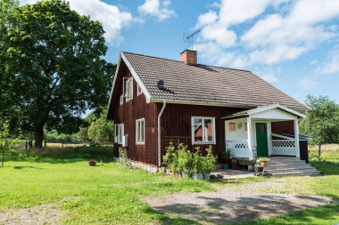 Ulva, Uppland - İsveç - 07 29 2019 Tipik kırmızı ahşap İsveç yazlık ve bahçe
