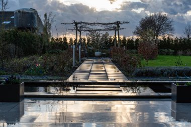 Echt, Limburg, Hollanda, 04 07 2022 - Gün batımında seramikleri yansıtan nemli arka bahçe