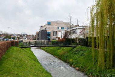 Sittard, Limburg, Hollanda - 04 08 2022 - Kentin banliyölerindeki Keutel deresi ve arka planda apartman blokları
