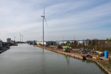 Genk, Limburg, Belçika - 04 12 2022 - Endüstriyel faaliyet ve Albert Kanalı 'nın kıyısında bir yel değirmeni fabrikası