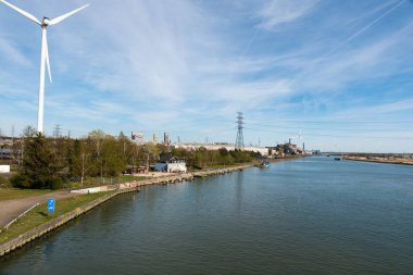 Genk, Limburg, Belçika - 04 12 2022 - Endüstriyel faaliyet ve Albert Kanalı 'nın kıyısında bir yel değirmeni fabrikası