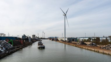 Genk, Limburg, Belçika - 04 12 2022 - Endüstriyel faaliyet ve Albert Kanalı 'nın kıyısında bir yel değirmeni fabrikası