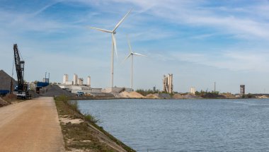 Lummen, Limburg, Belçika - 04: 12 2022 Sanayi bölgesinde bisiklet yolu ve yel değirmeni türbinleri olan Albert Kanalı