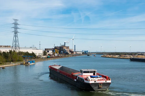 Genk, Limburg, Belçika - 04 12 2022 - Endüstriyel faaliyet ve Albert Kanalı 'nın kıyısında bir yel değirmeni fabrikası
