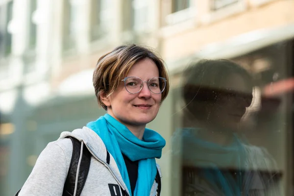 Mirrored portrait of a 35 year old woman wearing a grey hoody, Brussels, Belgium