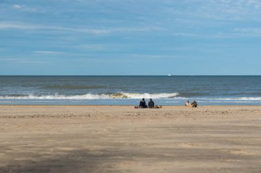 Ostend, West Flanders - Belgium 10 26 2019 People walking over the yellow sandy beaches with blue skies
