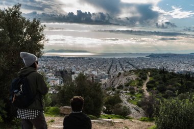 Atina Eski Kenti, Attica, Yunanistan - 12 28 28 2019 Atina ufuk çizgisine bakan iki yürüyüşçü