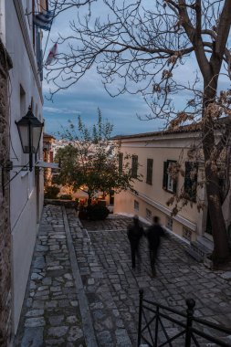 Atina Eski Kenti, Attica, Yunanistan - 12.28 2019 Pedestrains Eski şehrin kaldırımlı sokaklarında gün batımında yürüyor
