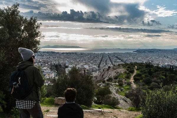 Atina Eski Kenti, Attica, Yunanistan - 12 28 28 2019 Atina ufuk çizgisine bakan iki yürüyüşçü