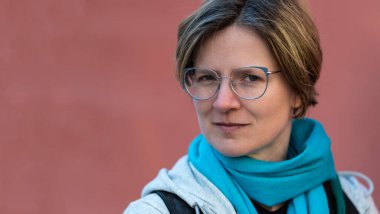 35 yaşında, kendine güvenen beyaz bir kadının portresi. Somon pembe bir geçmişi var. Brüksel, Belçika.