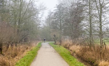 Jette, Brüksel Başkent Bölgesi Belçika - 01 24 2020 Öğrenci Kız Baudouin şehir parkında bir köy yolunda yürüyor