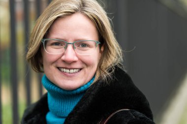 Endüstriyel çitlere karşı poz veren, siyah kürklü bir kadın portresi, Anderlecht, Belçika