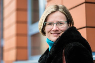 Brüksel, Belçika 'da turuncu bir duvara poz veren mutlu 30 yaşında bir kadının portresi