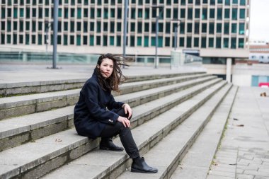 Açık hava portresi. 28 yaşında, kahverengi saçlı beyaz bir kadın. Rüzgarda, Brüksel, Belçika.