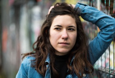 27 yaşında beyaz bir kadın, metal bir ızgaraya karşı poz veriyor, Brüksel, Belçika