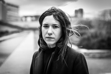 Açık havada, Brüksel Belçika 'nın merceğine cesurca bakan, kahverengi saçlı 28 yaşında beyaz bir kadının portresi.