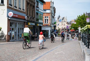 Mechelen, Antwerp Eyaleti, Belçika - 06 04 2022 - Anne ve kızı eski kasabanın sokaklarında bisiklet sürüyorlar