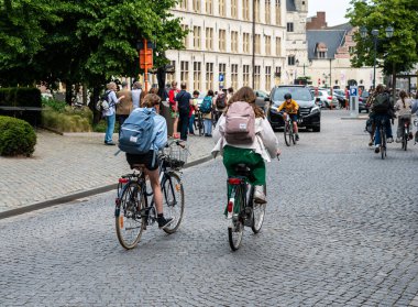Mechelen, Antwerp Eyaleti, Belçika - 06 04 2022 - Eski kasabadaki Ijzerenleen Köprüsü 'nde bisiklet süren liseli gençler